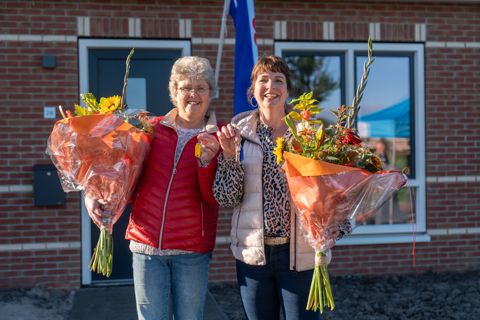 Twee nieuwe bewoners  voor hun huis ontvangen bloemen en sleutels van WoonFriesland